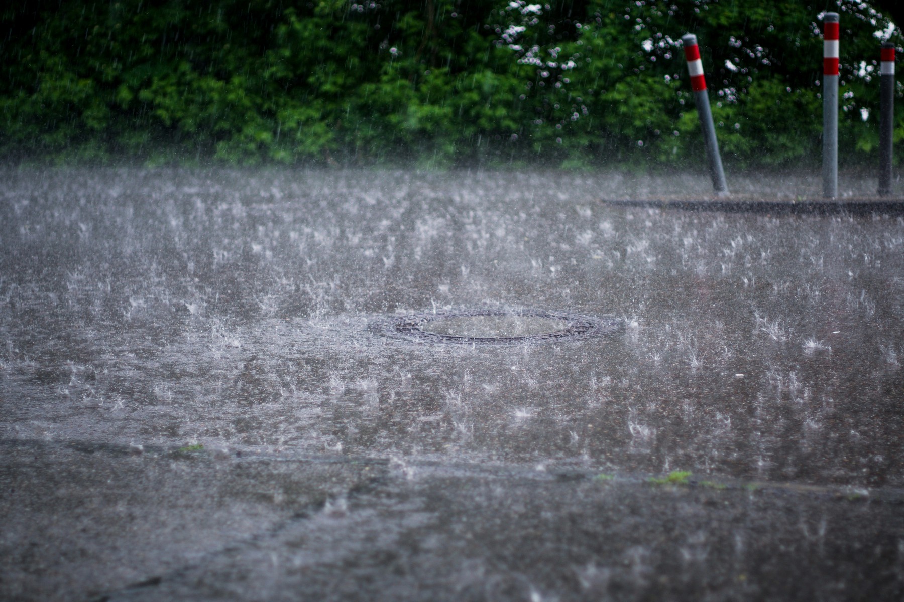 Starkregen läuft in einen Straßenabfluss